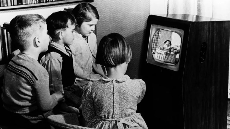 An image of kids watching a show on a black-and-white television. | Source: BBC