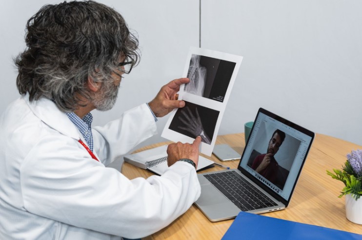 A doctor discussing X-ray results with a patient during a virtual consultation. Source: Envato Elements